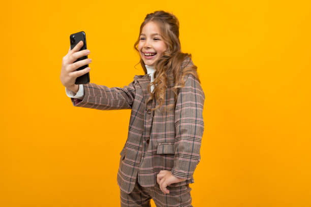 istock girl in classic style makes selfie on the phone in the studio 1284477509