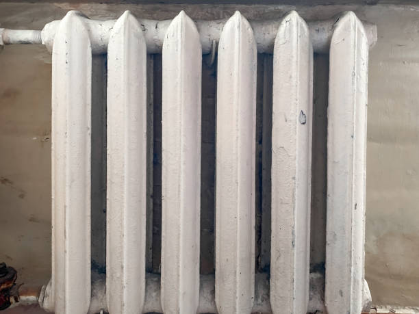 istock White cracked paint on an old cast-iron radiator with bobweb, spiderweb in an apartment needed to be replaced or repared 1284477720