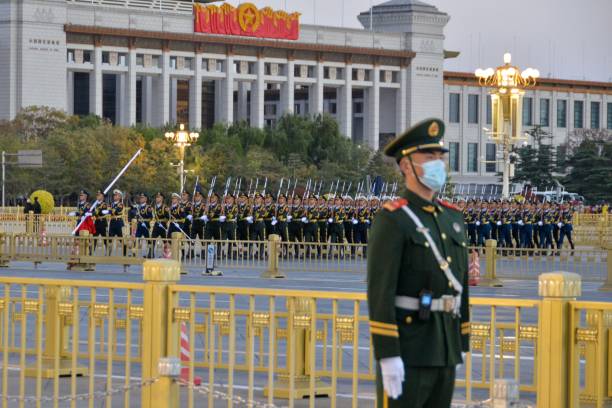 The Flag-lowering Ceremony in Tian'anmen Square,Beijing Beijing, China- November 7, 2020: In the heart of Beijing-the politics center of China, there is a national flag lowering ceremony everyday in Tian'an Square. It attracks many tourists from all over the country. Here are the Natioal Flag Guards who taking the National Flag back after the ceremony. pla symbol stock pictures, royalty-free photos & images