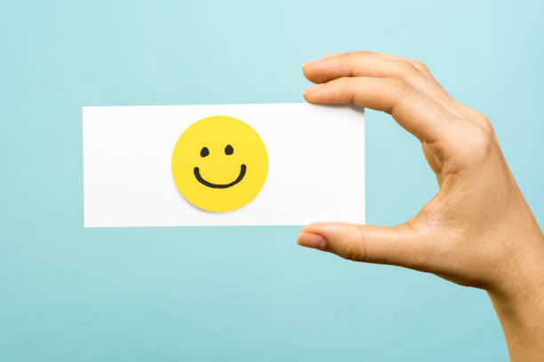 Drawing of a happy smiling emoticon on a yellow paper and white background. Hapiness concept. Drawing of a happy smiling emoticon on a yellow paper and white background. Hapiness concept. anthropomorphic smiley face photos stock pictures, royalty-free photos & images