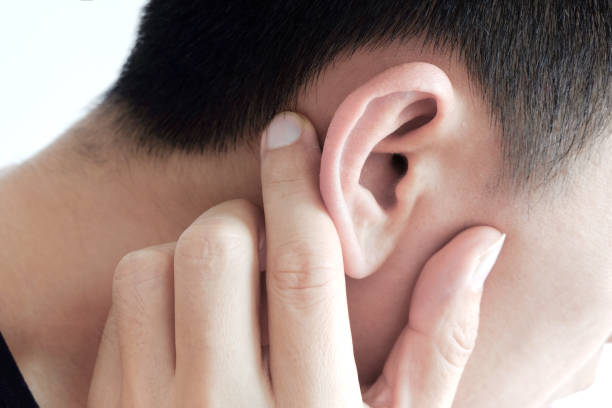 The young man touched his ear and he had a sore ear. stock photo