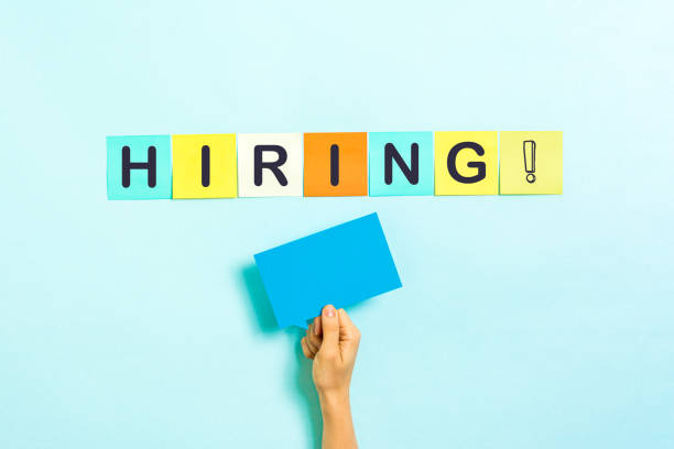 istock Hiring text on sticker notes with empty space for text on blue background. Job board design, template. Concept of recruitment and job search. 1284485339