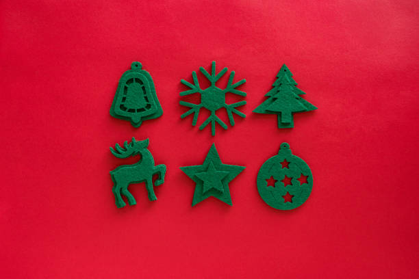 istock Kraft felt green toys composition. Christmas decorations on red surface. Felt decor - deer, snowflake, bauble, tree, star. Top view, flat lay 1284493266