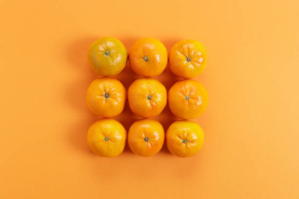 istock fresh oranges on orange color paper background 1284494694