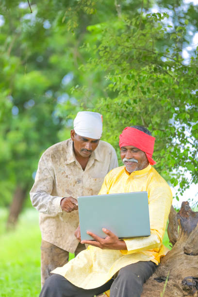 istock Indian farmer using laptop at field and showing some information to labor 1284506989