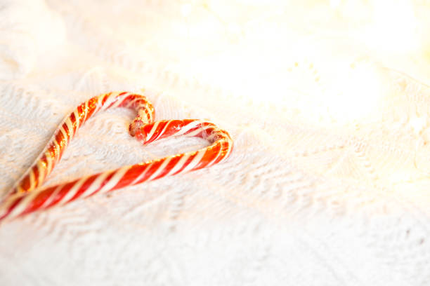 canne de noël rayé santa sous forme de coeur sur une couverture tricotée blanche. - christmas crutch holiday christmas decoration photos et images de collection