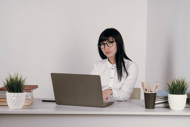 istock Head shot pleasant happy young woman freelancer working on computer at home. 1284509626