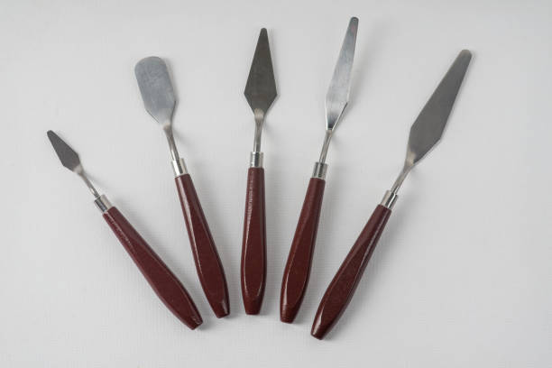 istock Five art palette knives lie on a white art canvas 1284509717
