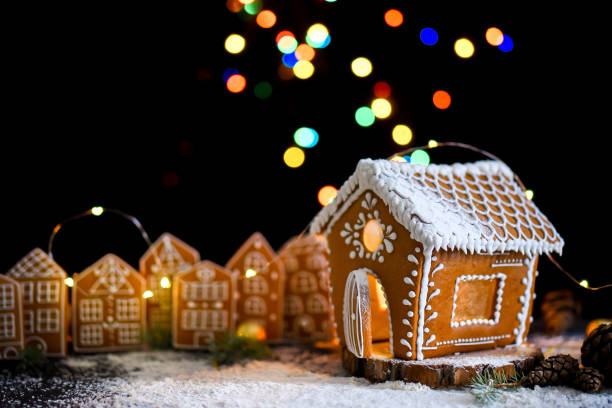 istock Winter gingerbread house with light from the windows, gingerbread city, big side lights, snow. Christams card. 1284510397