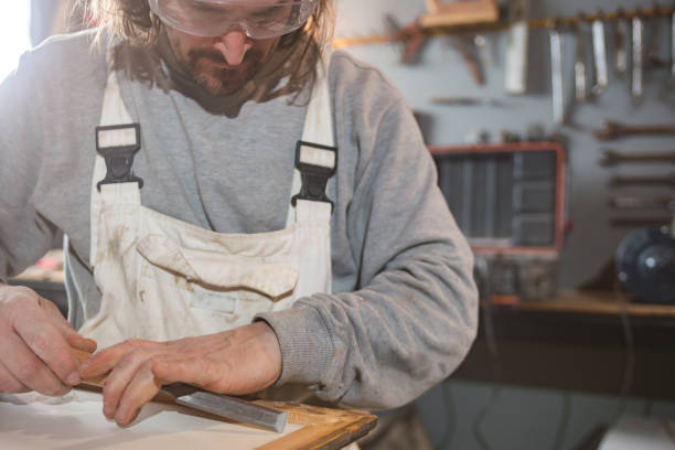 istock Male carpenter working on old wood in a retro vintage workshop. 1284516976