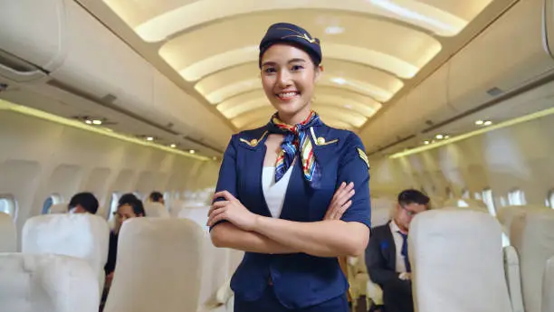 Cabin crew or air hostess working in airplane . Airline transportation and tourism concept.