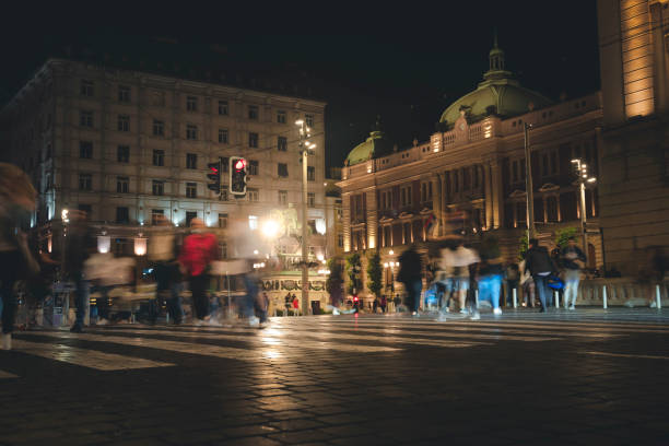 Pedestrian crossing in the historic center of Belgrade, blurred figures of people in the night city Pedestrian crossing in the historic center of Belgrade, blurred figures of people in night city knez mihailova stock pictures, royalty-free photos & images