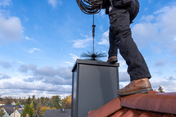 spazzacamino spazzare pulizia di un camino in piedi sul tetto della casa, abbassando l'attrezzatura lungo la flue - chimney sweeping foto e immagini stock