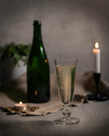 moody atmosphere with a large glass of champagne by candlelight