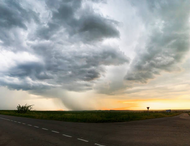 istock Horizontal panorama with a beautiful thundercloud and heavy rain over the road and roadside. 1284527859