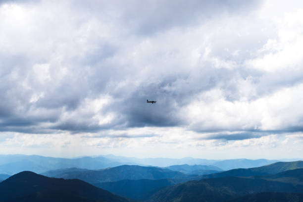 istock Airplane among clouds in mountains. Transport. Aircraft 1284531791