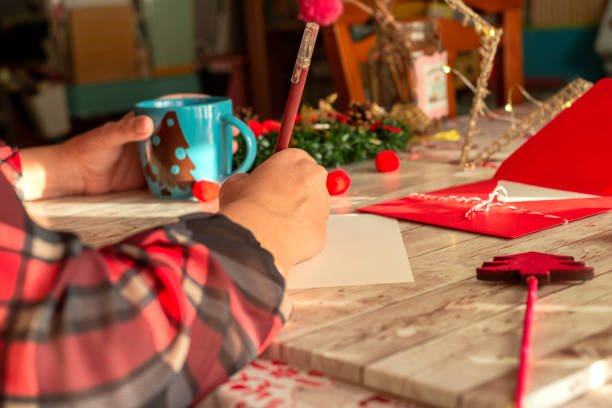 A woman writing a Christmas card stock photo