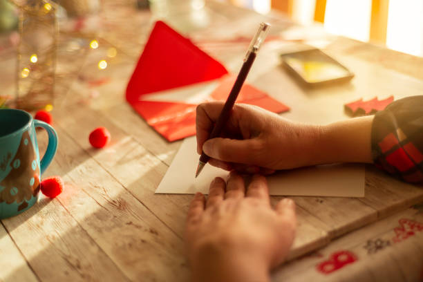une femme écrivant une carte de noël - christmas christmas ornament human hand decoration photos et images de collection