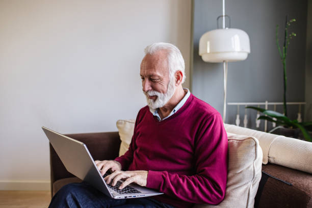 istock Senior man with laptop at home 1284539523