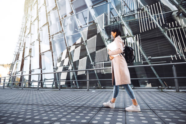istock Woman college student wearing a face mask on her way to class 1284540096