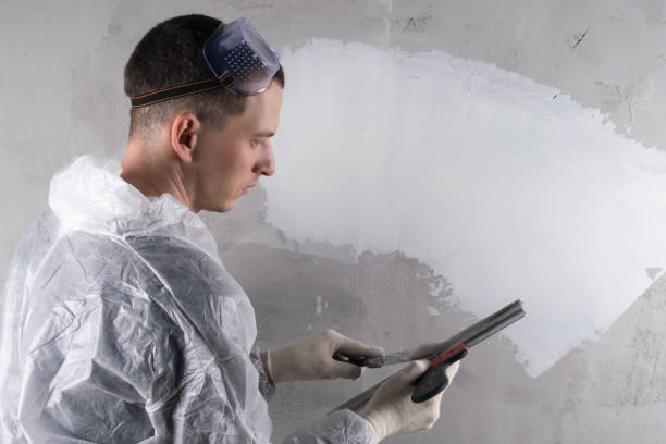 istock a repairman holds a tool for applying putty on the wall 1284541505