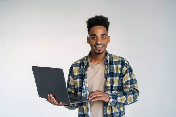 istock Young african american man using a laptop, isolated on white background 1284543636