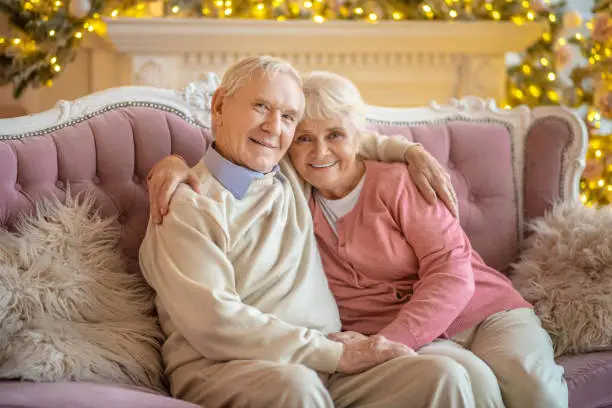 Happy people. Elderly couple sitting on a sofa and hugging