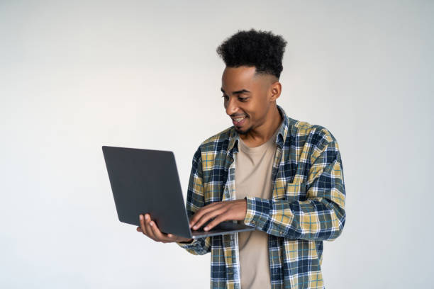 istock Young african american man using a laptop, isolated on white background 1284546344