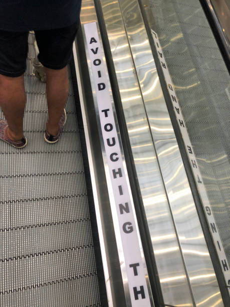 istock Image of unrecognisable person using metal steps on an escalator with large red, spray painted crosses, Coronavirus social distancing regulations on moving staircase steps, Covid-19 safety 1284547040