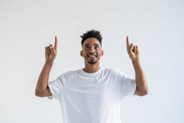 istock Successful man. Handsome young African man in formalwear pointing up and smiling while standing isolated on white background 1284547093