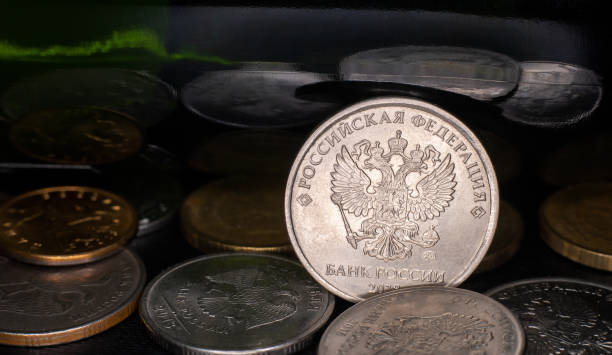istock coin ruble between other rubles and green mirror background 1284548447