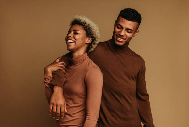 glimlachende afrikaanse amerikaanse man en vrouw die zich samen bevinden - men's fashion stockfoto's en -beelden