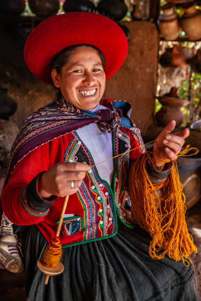 istock Peruvian woman spinning wool by hand, Sacred Valley, Peru 1284549885