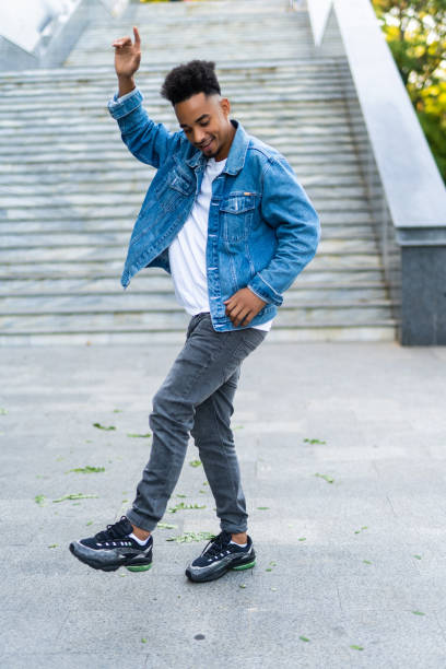istock Joyful young african man dancing outdoors in the street 1284550886