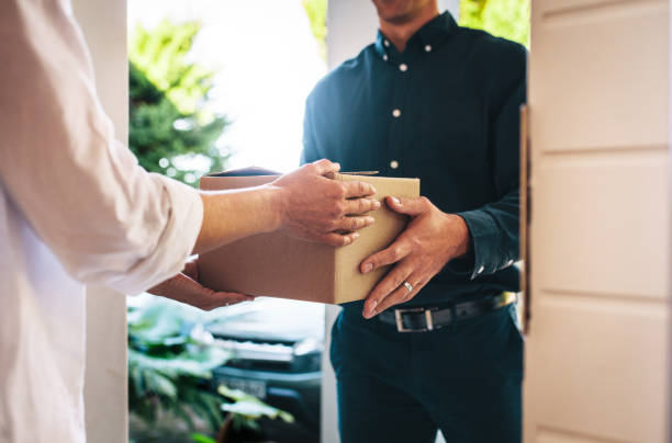 istock Woman receiving parcel from delivery man 1284550908