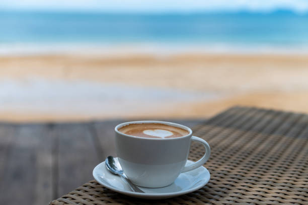 istock Latte art coffee cup on table near beach 1284556359