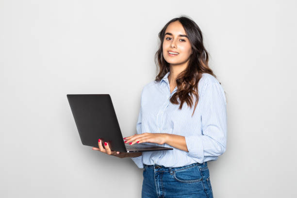 istock Pretty young girl using laptop over gray background 1284556776