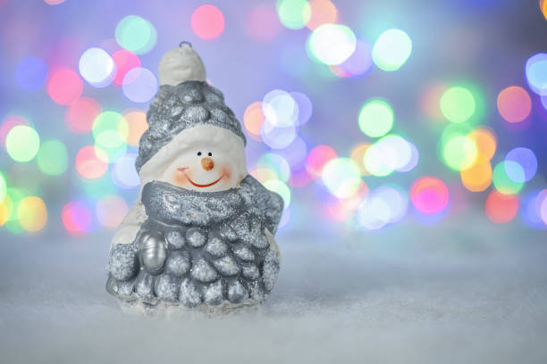 istock Christmas greeting card with decorative cute snowman. Bokeh effect on background 1284557581