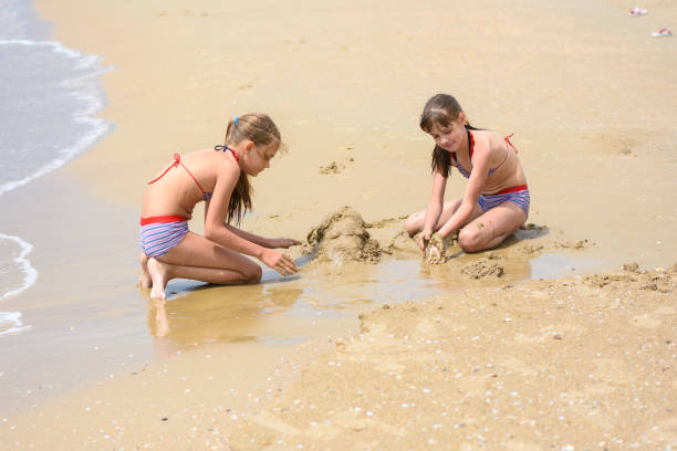 istock Two girls build sand castles on the seashore 1284559057
