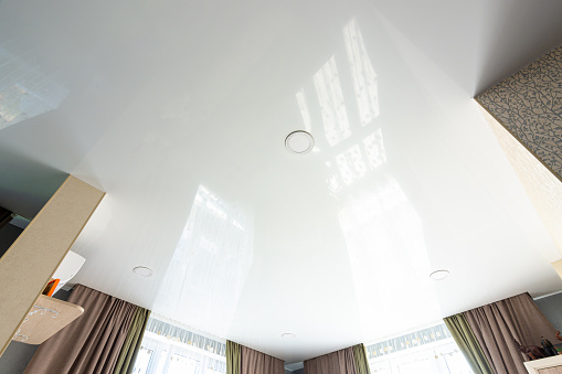 Classic white glossy ceiling with recessed spotlights
