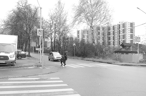 Moscow region, Russia - November 8, 2020: Father and son are crossing the street