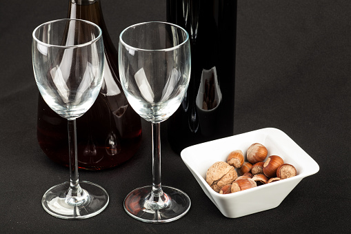 White wine on wooden white vintage table with green lawn on background