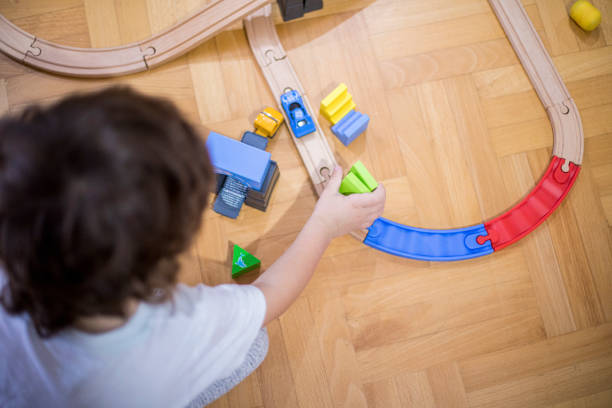 istock Little boy playing with a railroad train toy. 1284564301