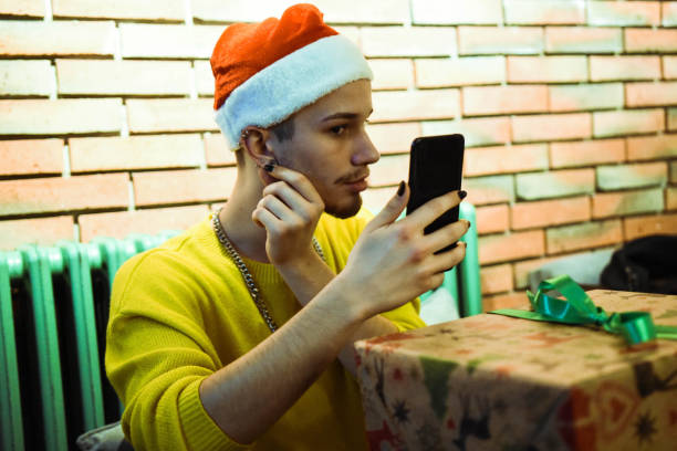 istock Young beautiful queer man packs Christmas presents 1284564309