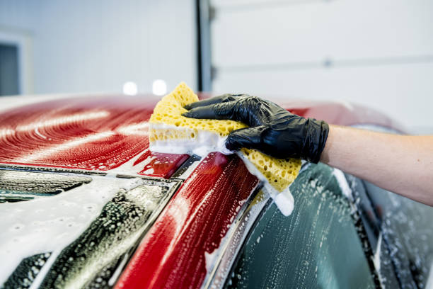 istock Worker washing red car with sponge on a car wash 1284567562