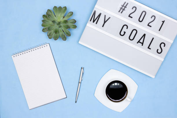 istock Blank notebook, pen, coffee cup, lightbox with My Goals text on office desk. Plans for the coming year concept 1284571820