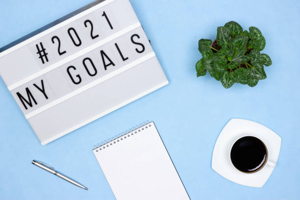 istock Plans for the coming year concept. Notepad, pen, coffee cup, lightbox with My Goals text on the desk - top view 1284571839