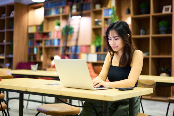 istock Asian woman telecommuting from cafe 1284573150