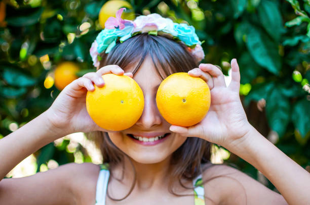 piękna dziewczyna pozowanie do organicznych drzew pomarańczowych - beautiful people citrus fruit fruit zdjęcia i obrazy z banku zdjęć