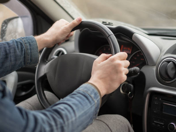 istock Male hands on steering wheel, inside cab, close up. Man driving a car. 1284576976